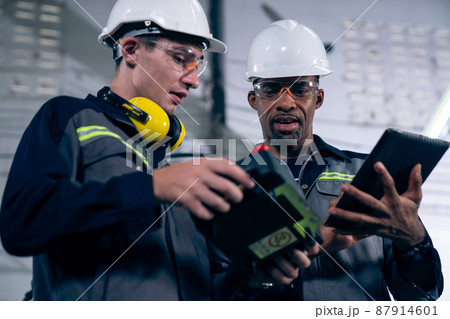 Group of factory job workers using adept machine equipment in a workshop 87914601