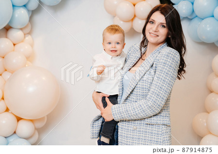 happy mom and son in front of the photo zone with balloons happy mom and son in front of the photo zone with balloons 87914875