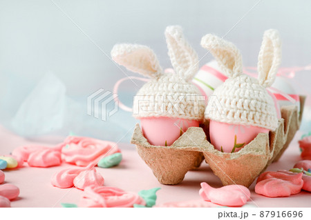 Happy Easter holiday concept with cute handmade eggs, knitted bunny hats and sweet pink decor, copy space. Greeting card, banner for your site, flyer, banner, invitation, discount card 87916696