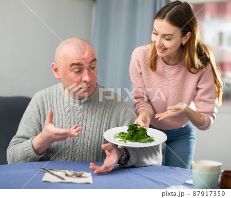 Woman serving salad for her husband at home 87917359