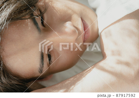 日差しを浴びる若い男性 87917592