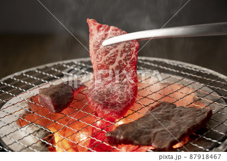 赤身の肉を炭火の七輪で焼く 87918467
