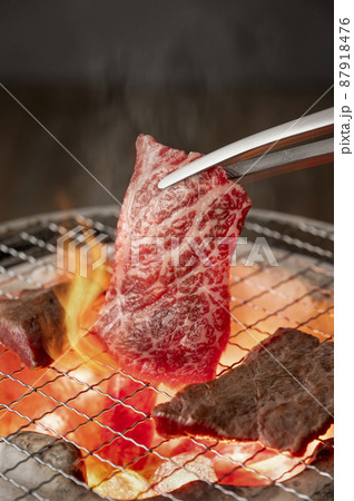 赤身の肉を炭火の七輪で焼く 87918476