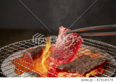 赤身の肉を炭火の七輪で焼く 87918479
