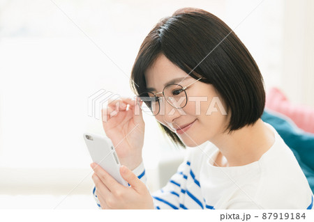 メガネをかけてスマホを見る女性 87919184