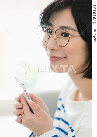 メガネをかけてスマホを見る女性 メガネをかけてスマホを見る女性 87919191