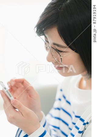 メガネをかけてスマホを見る女性 メガネをかけてスマホを見る女性 87919194