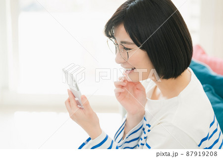 メガネをかけてスマホを見る女性 メガネをかけてスマホを見る女性 87919208