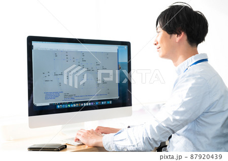 パソコンの前に座る男性電気系エンジニア パソコンの前に座る男性電気系エンジニア 87920439