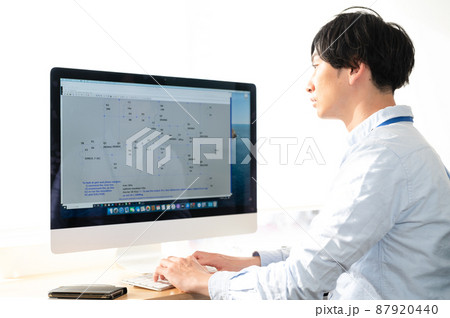 パソコンの前に座る男性電気系エンジニア パソコンの前に座る男性電気系エンジニア 87920440