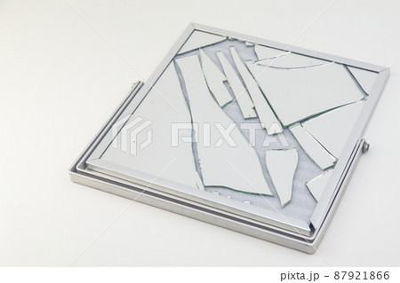 Broken mirror with silver frame on white background Broken mirror with silver frame on white background 87921866