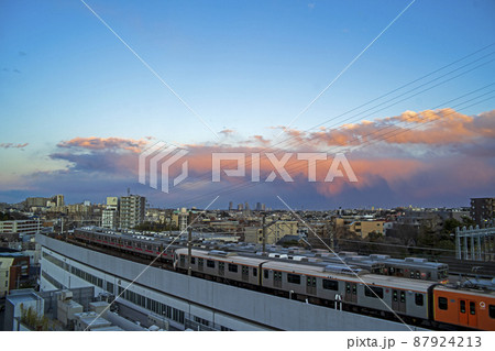 通勤電車の車庫の空に紅い夕焼け雲 87924213