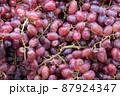 Bunch of colorful grapes with leaves 87924347