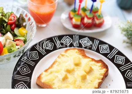 キューブ状チーズトッピングのチーズトーストとサラダとピンチョス　ランチ　朝食 87925075