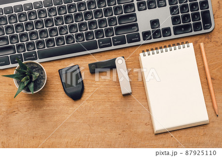 Hardware Wallet for cryptocurrency and keyboard on table with note 87925110