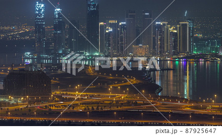 Dubai Creek Harbor with skyscrapers and towers under construction aerial night timelapse 87925647
