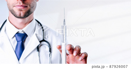 Syringe needle medical injection. Selective focus, doctor hand in blue gloves holding syringe with needle. Hospital white doctor gown, stethoscope. Syringe with flu vaccine with copy space. Syringe needle medical injection. Selective focus, doctor hand in blue gloves holding syringe with needle. Hospital white doctor gown, stethoscope. Syringe with flu vaccine with copy space. 87926007