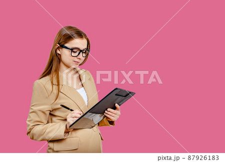 Concentrated female student writing in notebook while learning. Concentrated female student writing in notebook while learning. 87926183