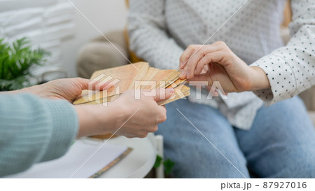 Psychologist uses metaphorical associative cards in a session with a patient. Close-up of female hands. 87927016