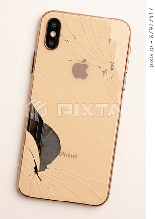 Top view the back of smartphone iPhone 11 with a broken glass and a damaged curved body close-up 87927617