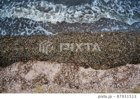 top view, dramatic seascape as background, gloomy sea and waves, coastline with seashells, wild landscape of late autumn, cloudy weather 87931513