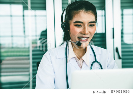 Doctor wearing headset talking actively on video call in hospital or clinic 87931936