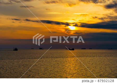 Beautiful sunset in the sea and ships. The sun shines through the clouds and is reflected in the waves Beautiful sunset in the sea and ships. The sun shines through the clouds and is reflected in the waves 87932128