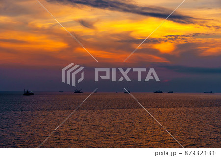 Beautiful sunset in the sea and ships. The sun shines through the clouds and is reflected in the waves 87932131