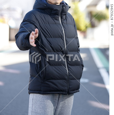 街にたたずむダウンジャケットを着た男性 87932945