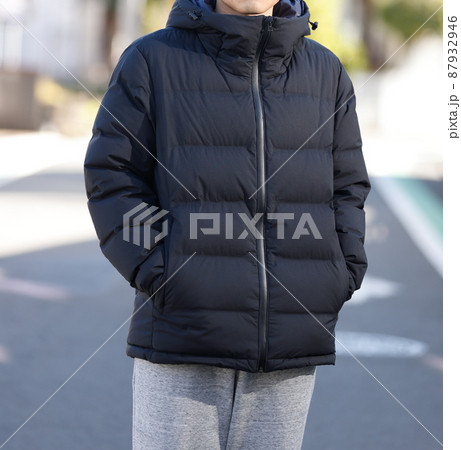 街にたたずむダウンジャケットを着た男性 87932946