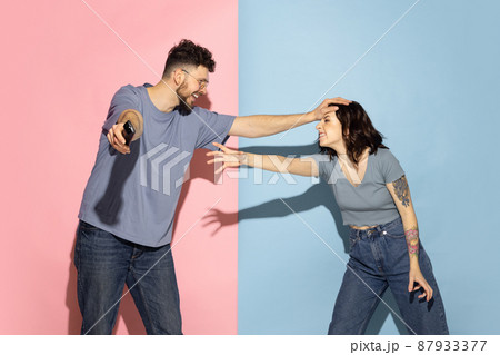 Portrait of young emotional man and girl isolated on blue and pink trendy color background. Human emotions concept Portrait of young emotional man and girl isolated on blue and pink trendy color background. Human emotions concept 87933377