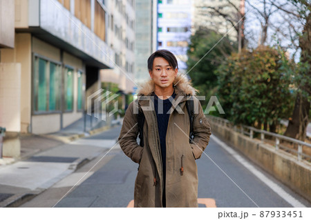道路の真ん中で立ち止まる20代の日本人男性 道路の真ん中で立ち止まる20代の日本人男性 87933451