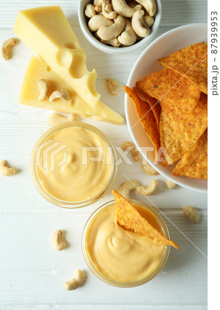 Snacks with cheese sauce on white wooden table 87939953
