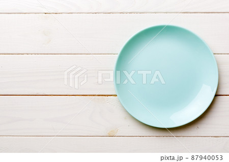 Top view of empty blue plate on wooden background. Empty space for your design 87940053