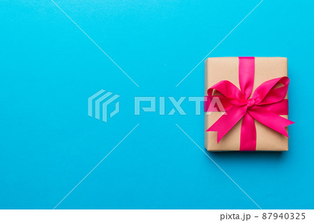 Holiday present box over colored background, top view. Copy space for design Holiday present box over colored background, top view. Copy space for design 87940325