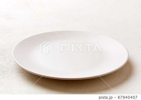 Perspective view of empty light plate on cement background. Empty space for your design 87940407
