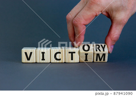 From victim to victory symbol. Businessman turns wooden cubes and changes concept words Victim to Victory. Beautiful grey background. Business support from victim to victory concept. Copy space. From victim to victory symbol. Businessman turns wooden cubes and changes concept words Victim to Victory. Beautiful grey background. Business support from victim to victory concept. Copy space. 87941090