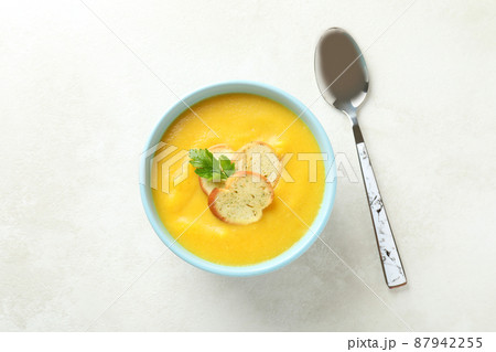 Plate of pumpkin soup and spoon on white textured table Plate of pumpkin soup and spoon on white textured table 87942255