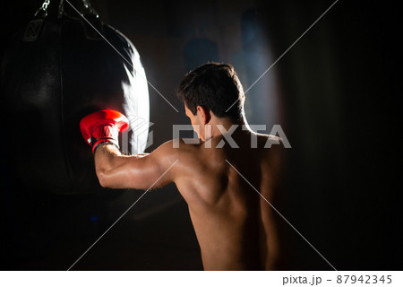 Dedicated sportsman punching boxing bag 87942345
