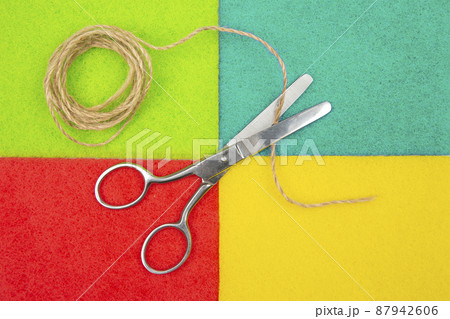 scissors for cutting and rope on a colored background scissors for cutting and rope on a colored background 87942606