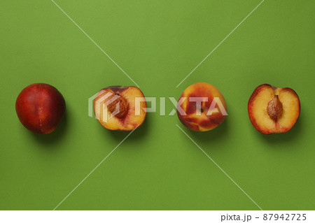 Fresh ripe peach fruits on green background 87942725