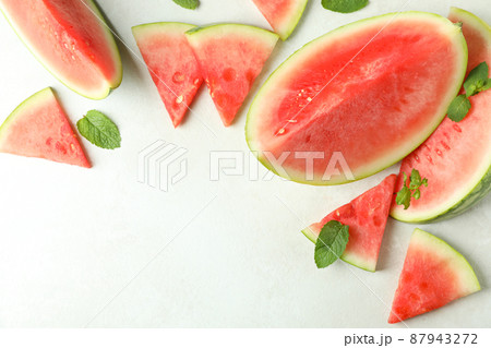Watermelon slices and mint leaves on white textured table Watermelon slices and mint leaves on white textured table 87943272