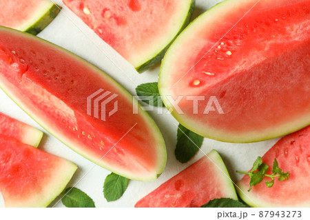 Watermelon slices and mint leaves on white textured table 87943273