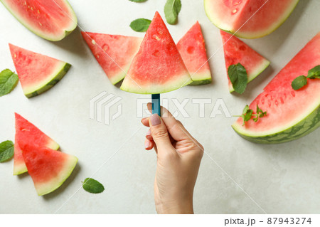 Female hand holds icecream stick with watermelon slice, close up 87943274