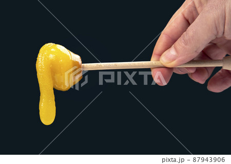 Fresh viscous flower honey falls down from a wooden spoon. vitamin organic food 87943906