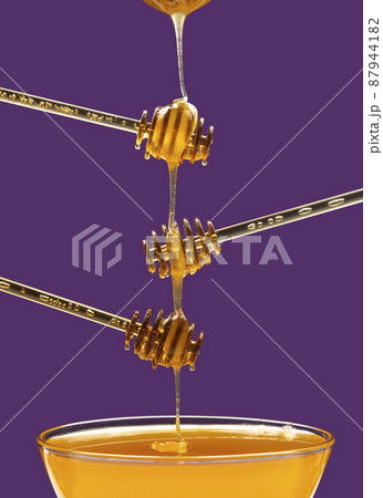 fresh honey drips from a spoon into a plate. organic vitamin health food 87944182