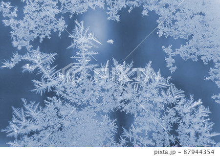 frosty patterns on the window glass closeup. natural textures and backgrounds frosty patterns on the window glass closeup. natural textures and backgrounds 87944354