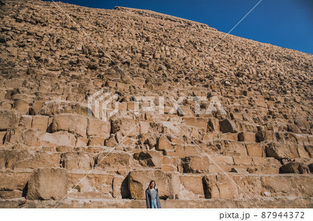 A European blonde walks near the pyramids in the desert in Cairo A European blonde walks near the pyramids in the desert in Cairo 87944372
