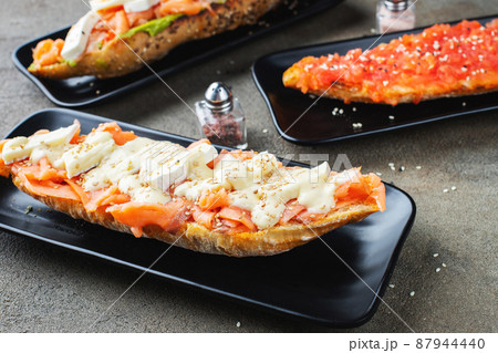 Traditional Spanish breakfast. Tostada with different toppings on a dark background 87944440