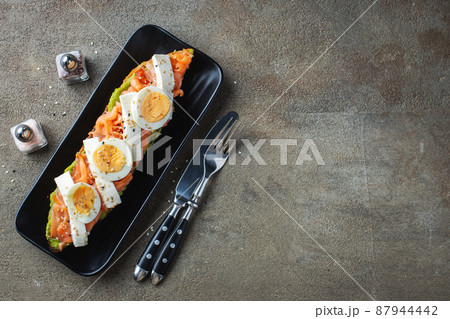 Traditional Spanish breakfast. Tostada with different toppings on a dark background. Top view with copy space 87944442